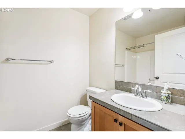 a bathroom with a granite countertop sink toilet and a mirror
