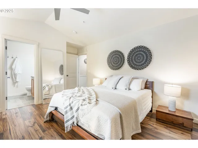 a bedroom with a bed and a table with wooden floor