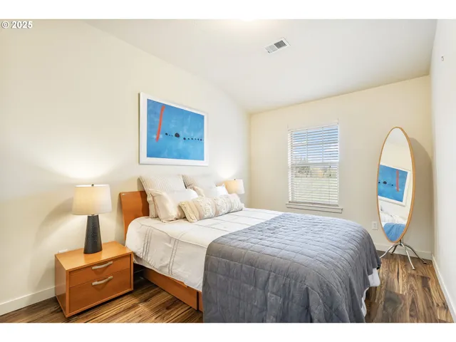 a bedroom with a bed and a painting on the wall