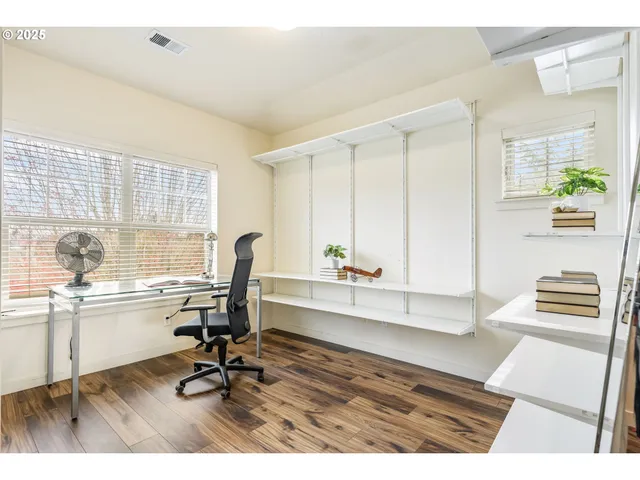 a view of a workspace with furniture and a window