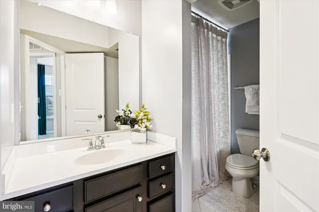 a bathroom with a granite countertop sink toilet a mirror and a shower