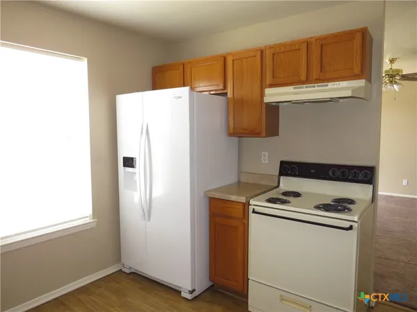 a white refrigerator freezer and a stove sitting inside of a kitchen