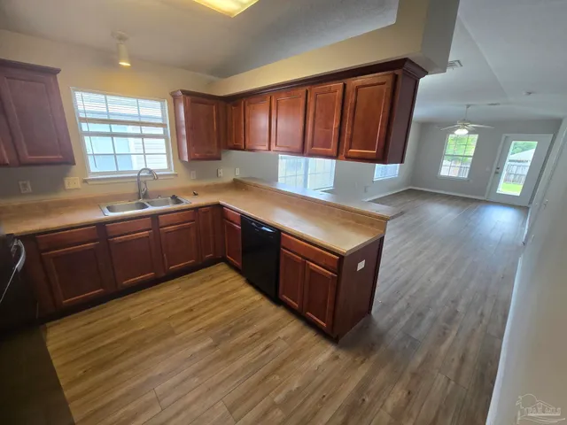 a kitchen with wooden cabinets sink and window