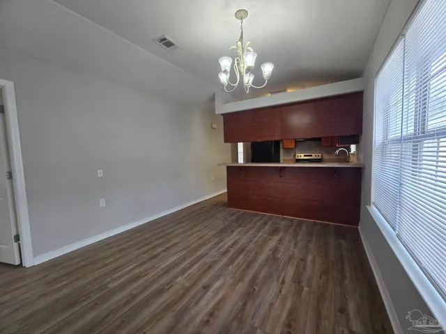 a view of a room with wooden floor and chandelier