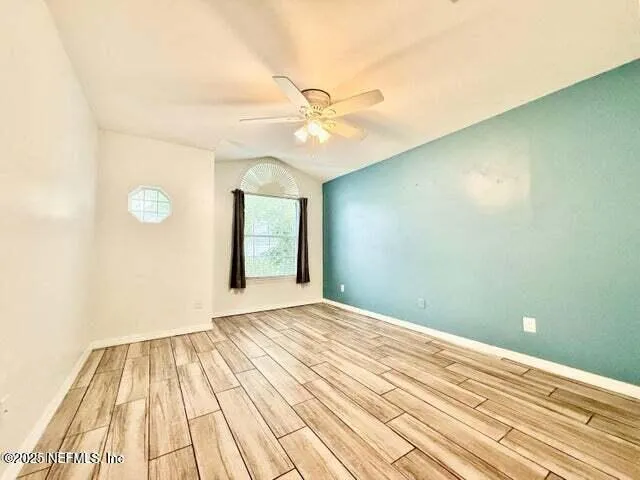 a view of a room with wooden floor closet and a ceiling fan
