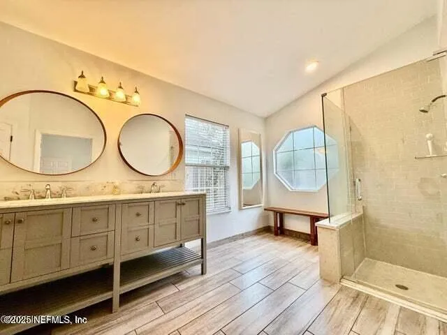 a bathroom with a sink shower and a mirror