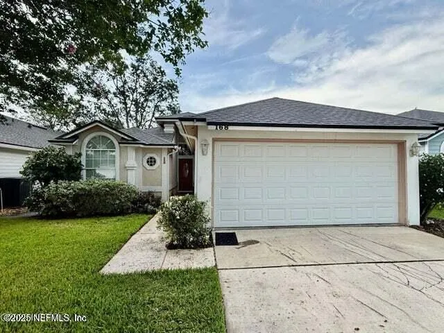 a front view of a house with a yard and trees