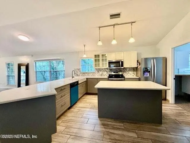 a kitchen with stainless steel appliances wooden floor dining table and chairs