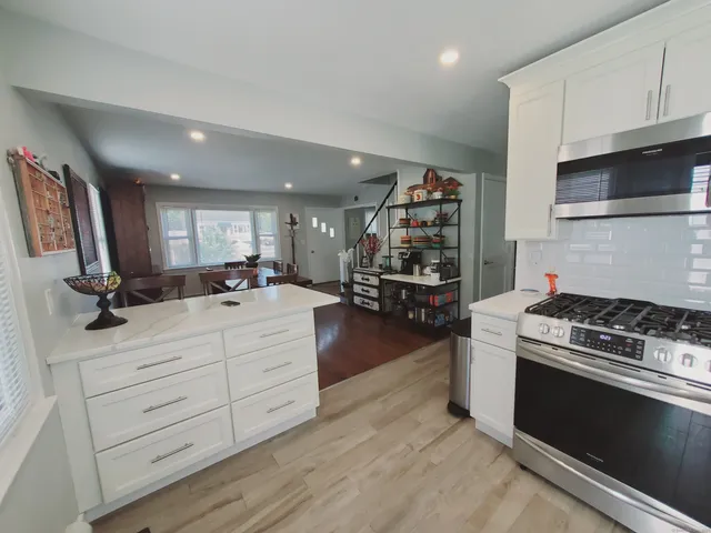 a kitchen with stainless steel appliances kitchen island granite countertop a stove and a sink