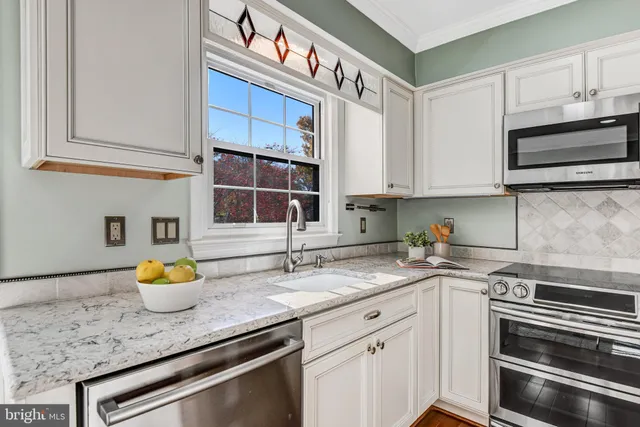 a kitchen with stainless steel appliances granite countertop a sink stove and cabinets