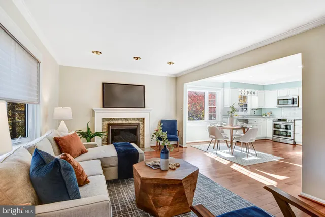 a living room with furniture a fireplace and a large window