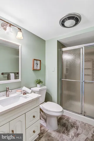 a bathroom with a granite countertop sink mirror vanity and toilet