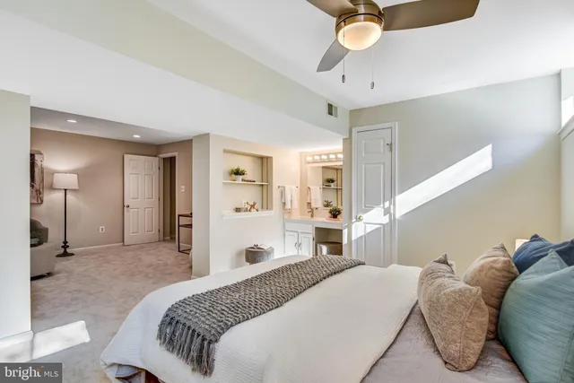 a spacious bedroom with a bed and ceiling fan