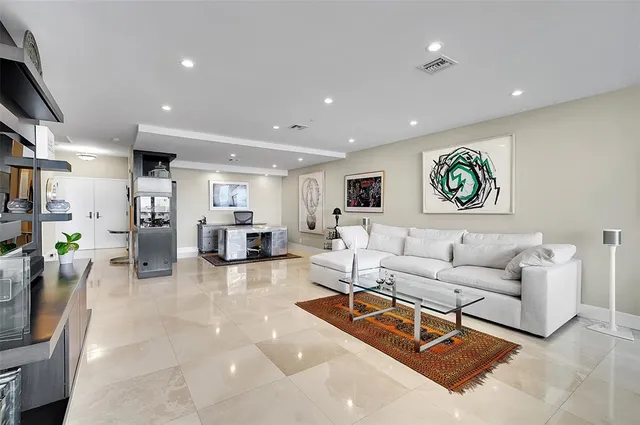 a living room with furniture kitchen view and a chandelier
