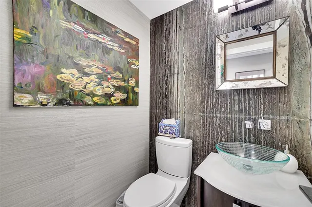 a white toilet sitting next to a bathroom sink