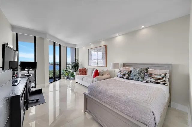 a living room with furniture a flat screen tv and a large window