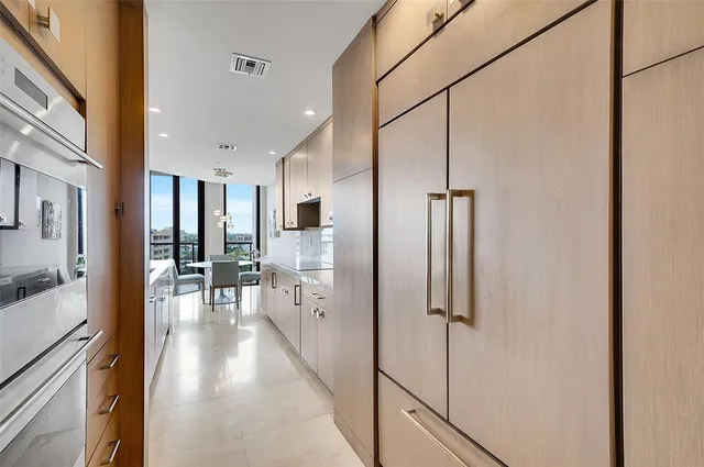 a view of a hallway with wooden floor and a living room