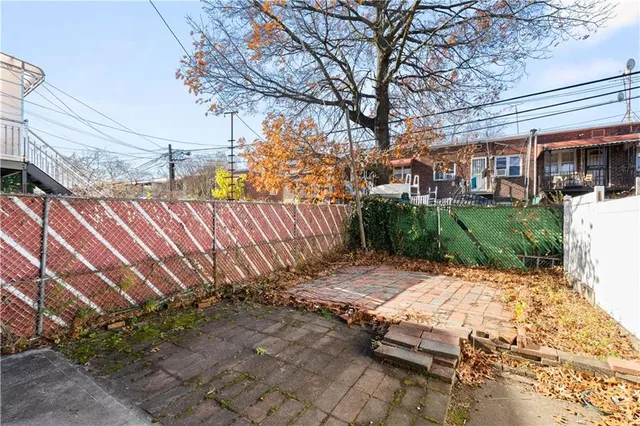 a view of backyard with a table and chair under an umbrella
