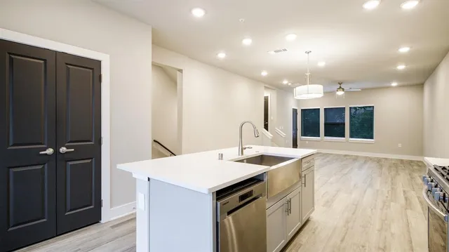 a view of a kitchen island a sink and dishwasher with wooden floor