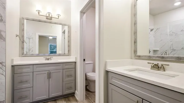a bathroom with a double vanity sink mirror and shower