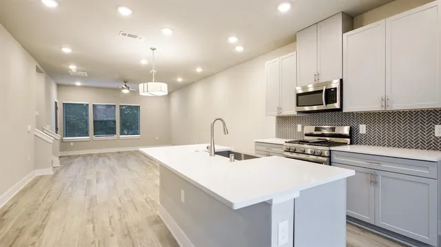 a kitchen with kitchen island a sink stainless steel appliances and cabinets