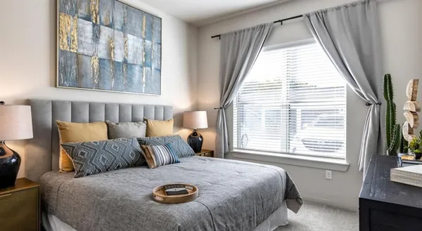 a large bed sitting in a bedroom next to a window
