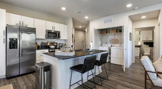 a kitchen with kitchen island a refrigerator stove microwave and cabinets