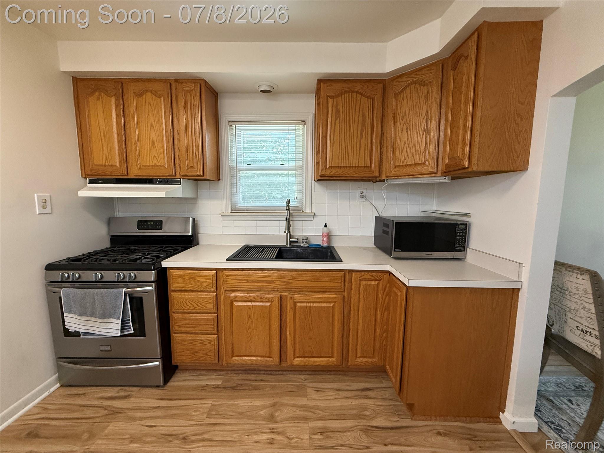 756 Cedarlawn Road Waterford, MI 48328 - Photo 11 of 34 Kitchen featuring honey-toned cabinetry, light-toned countertops, and wood-finish flooring
