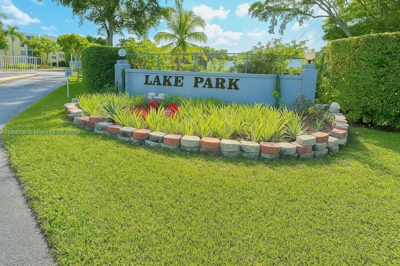 950 Northeast 199th Street, Unit 1A 101 Miami, FL 33179 - Photo 2 of 10 a sign that is sitting in the grass next to a road