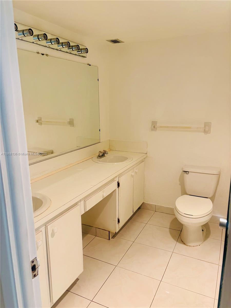 950 Northeast 199th Street, Unit 1A 101 Miami, FL 33179 - Photo 7 of 10 a bathroom with a sink a toilet and shower