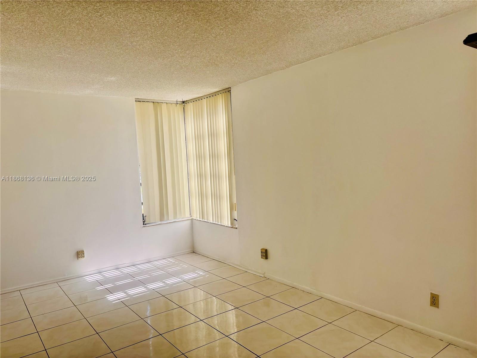 950 Northeast 199th Street, Unit 1A 101 Miami, FL 33179 - Photo 9 of 10 a view of an empty room and window