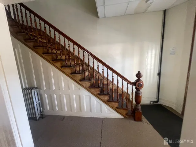 a view of staircase with railing and white walls
