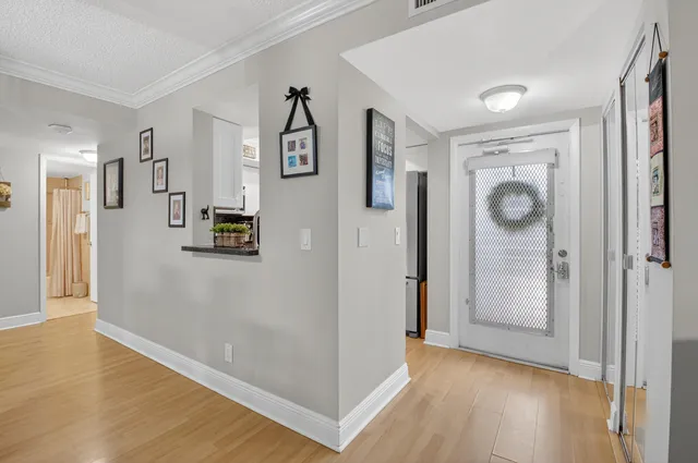 a view of a hallway with wooden floor and a cabinet