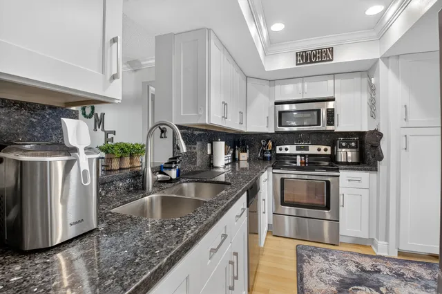 a kitchen with stainless steel appliances granite countertop a sink stove and refrigerator