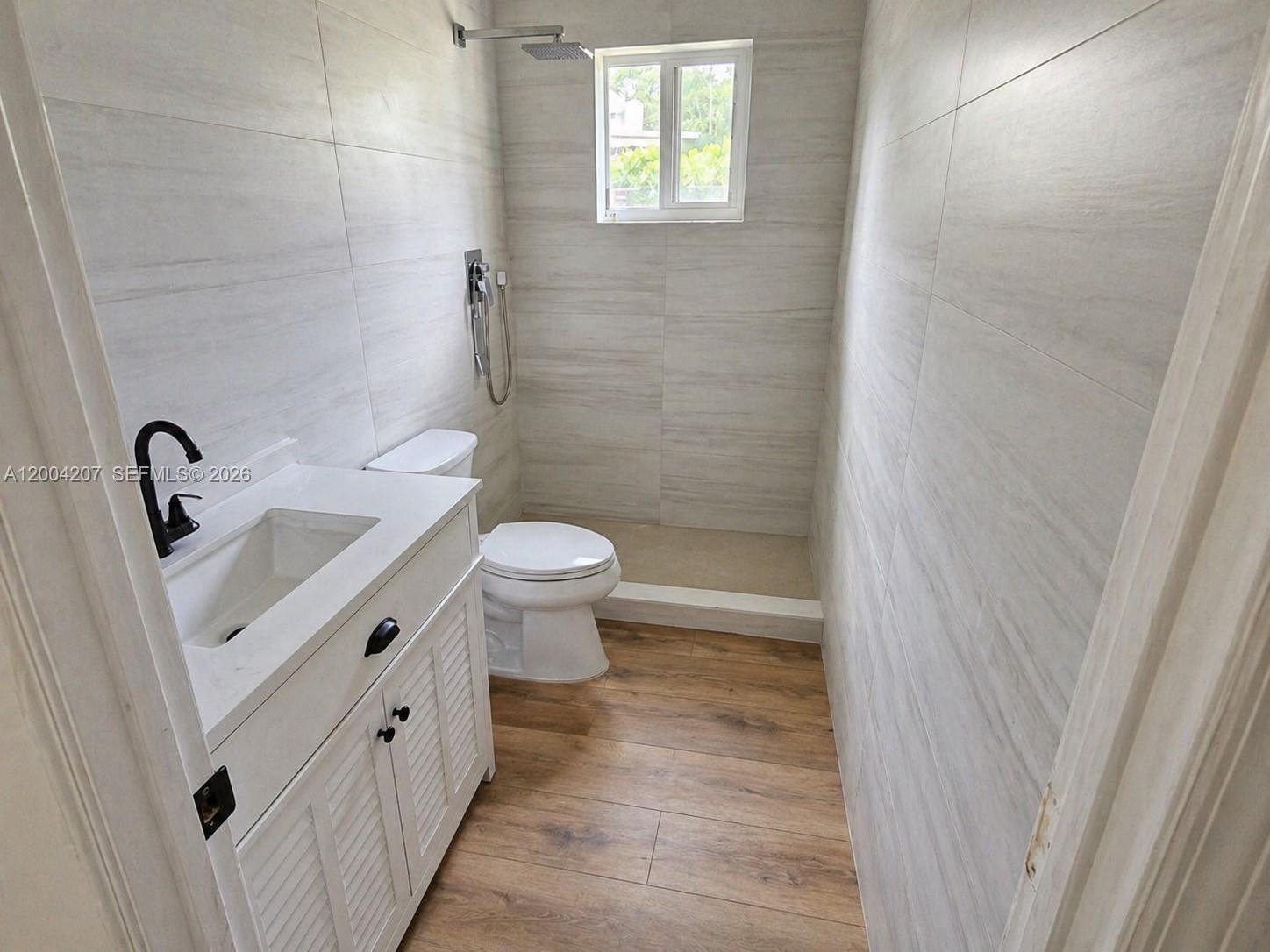 426 Southwest 26th Road Miami, FL 33129 - Photo 5 of 9 a bathroom with a sink a toilet a shower and a window