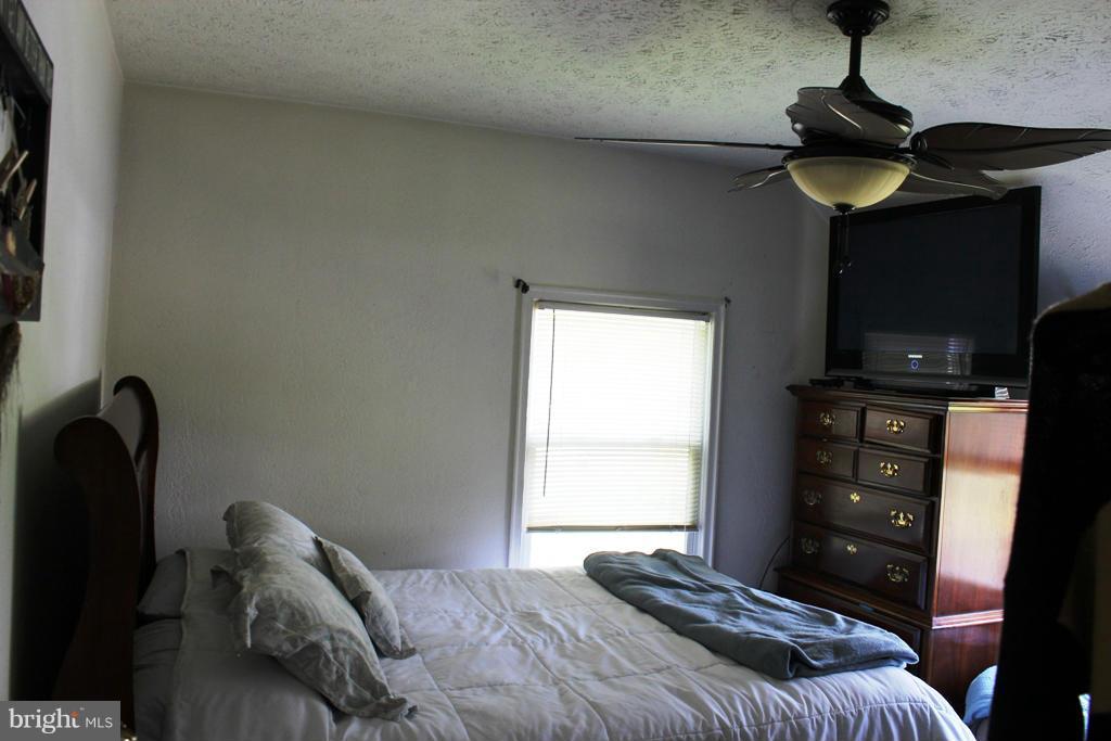 46695 Yorktown Road Lexington Park, MD 20653 - Photo 11 of 14 a bedroom with a bed and a chandelier