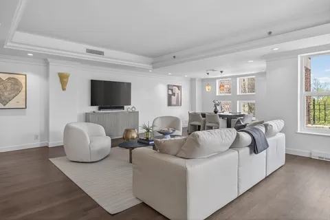 a living room with furniture a flat screen tv and a window