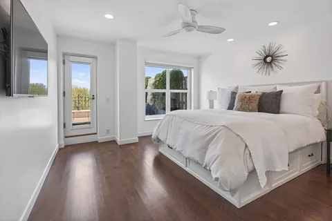 a spacious bedroom with a large bed chandelier and a window