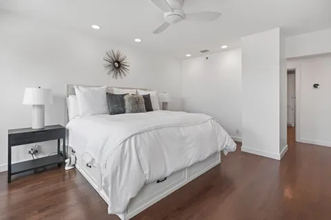 a spacious bedroom with a bed and a night stand