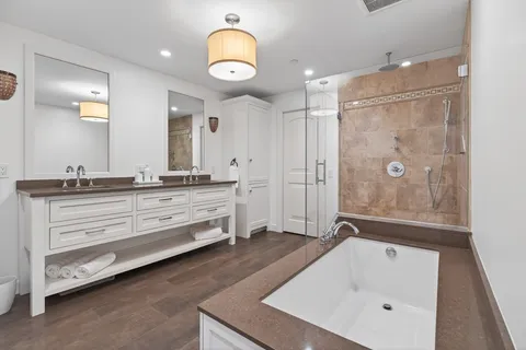 a bathroom with a tub sink and mirror