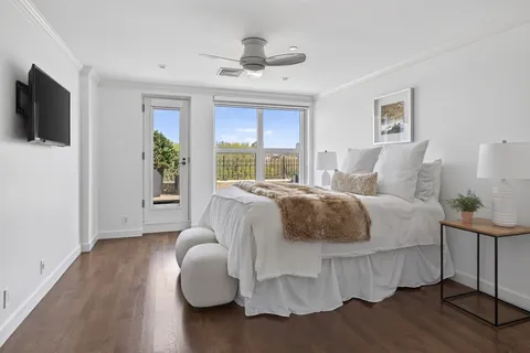 a large bed sitting in a bedroom next to a window with tv
