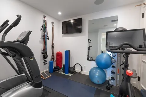 a view of a workspace with furniture and gym equipment