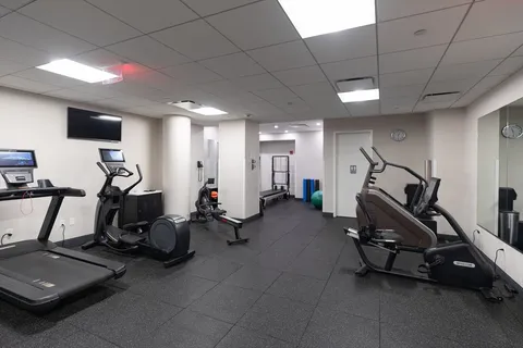 a room with gym equipment and a flat screen tv