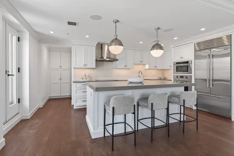 a kitchen with kitchen island granite countertop white cabinets and stainless steel appliances