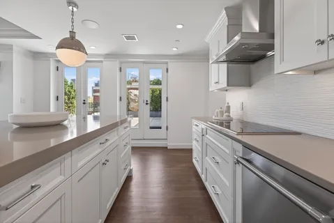 a large kitchen with stainless steel appliances lots of counter space and a sink