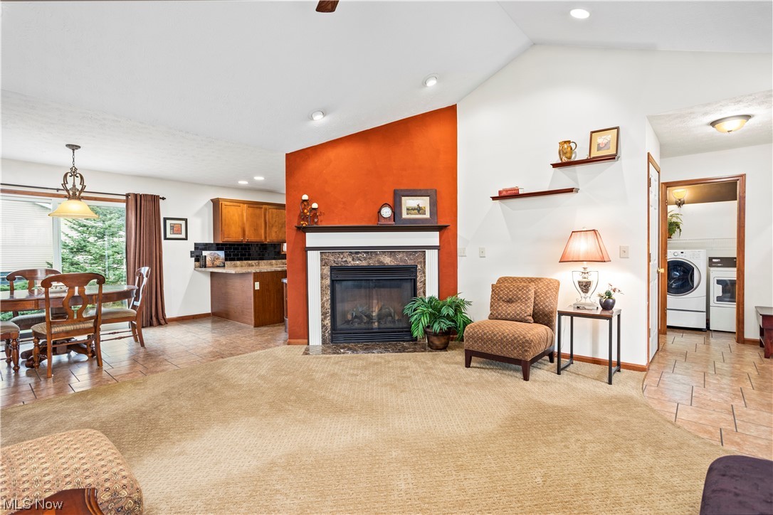 9240 Murray Ridge Road Elyria, OH 44035 - Photo 9 of 34 Carpeted living room with a fireplace and lofted ceiling