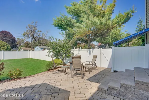 a white house with potted plants next to a yard