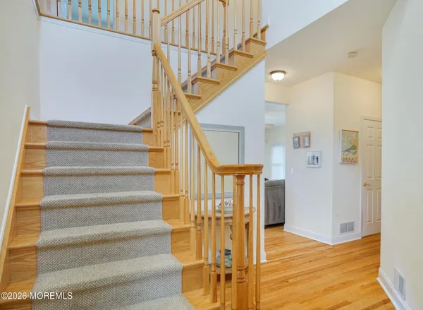 a view of entryway and hall with wooden floor