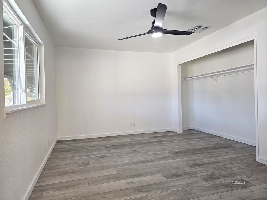3644 Alene Avenue Ridgecrest, CA 93555 - Photo 13 of 22 a view of an empty room with wooden floor and a window