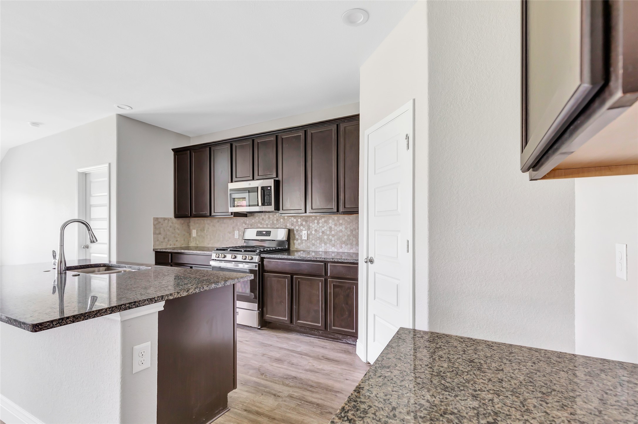 214 Kickapoo Drive Anahuac, TX 77514 - Photo 14 of 36 a kitchen with stainless steel appliances granite countertop a sink stove and refrigerator